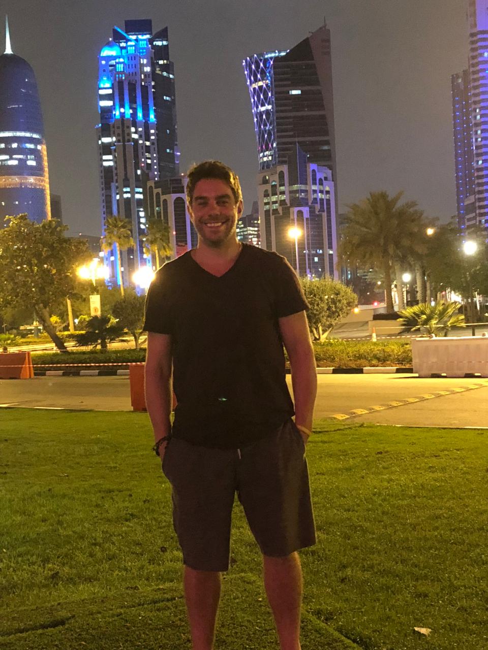Kaká em Doha à noite, com prédios iluminados ao fundo