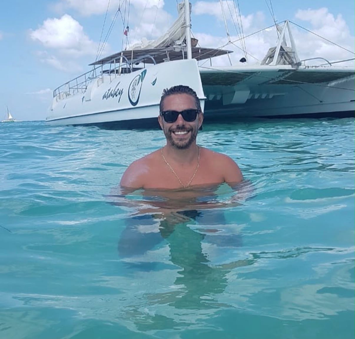 Kaká no mar de Punta Cana, com um catamarã ao fundo